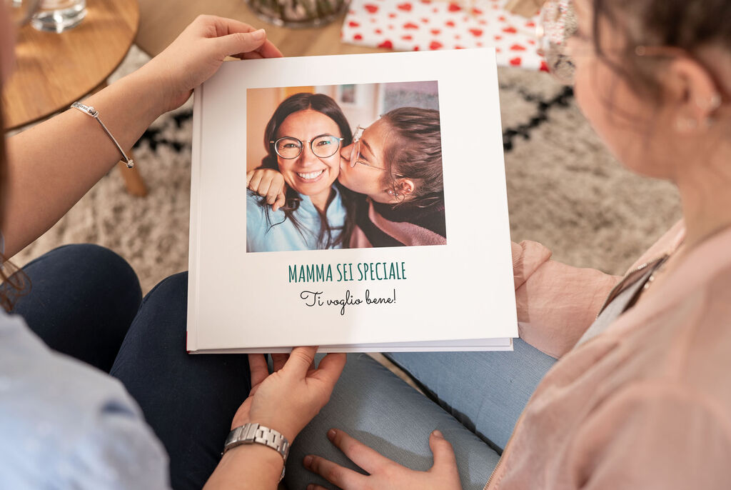 Due persone tengono un fotolibro ricco di ricordi affettuosi.