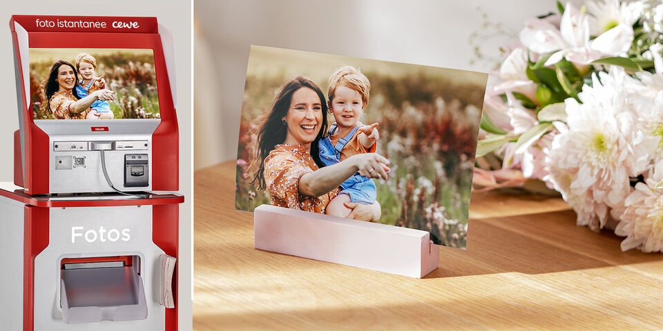 Due persone sorridono e tengono un bambino in un prato fiorito. Su un tavolo c'è un porta foto con l'immagine, circondato da fiori.