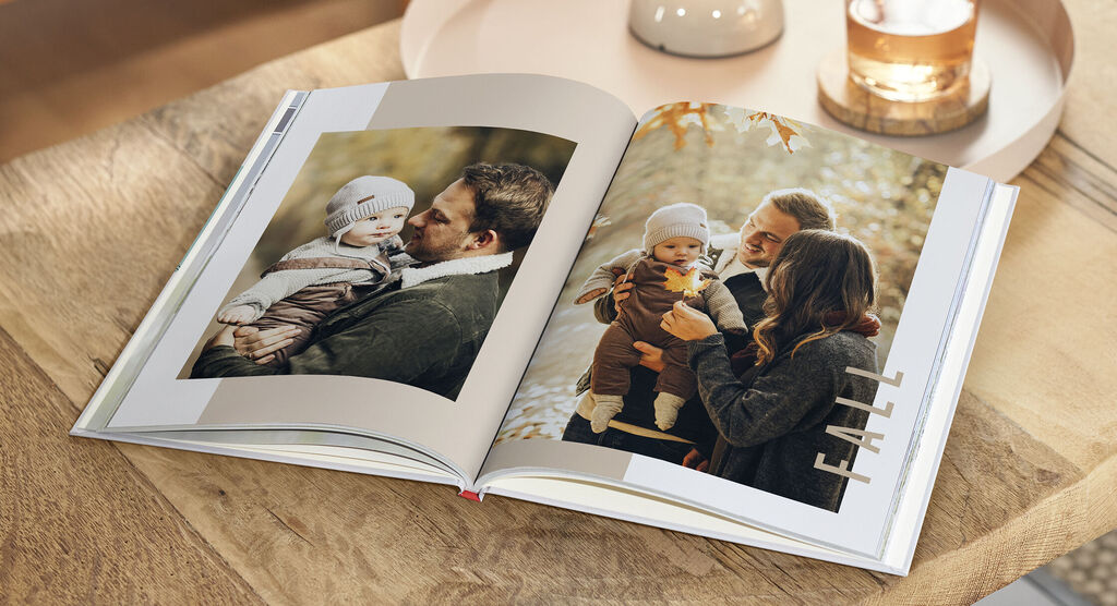 Un album fotografico aperto mostra momenti felici di famiglia in autunno.