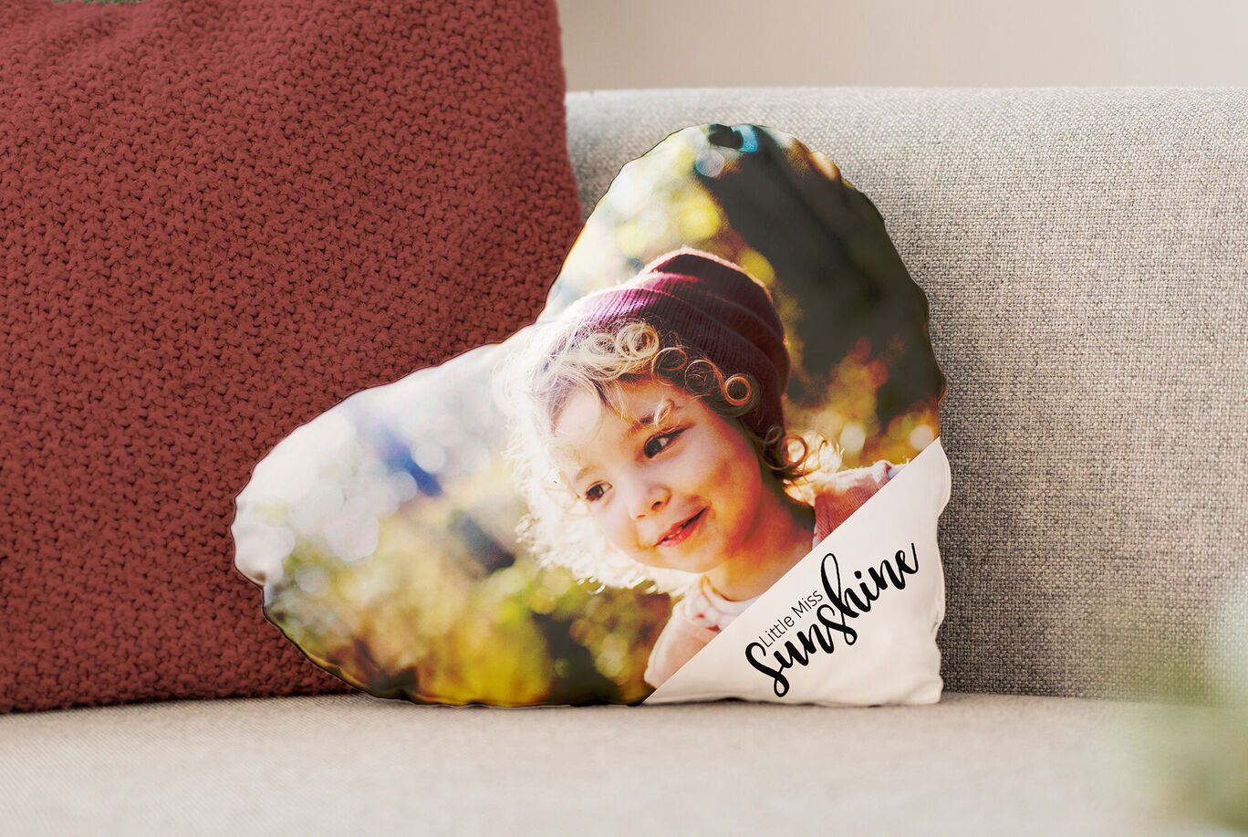 Un cuscino a forma di cuore con colori caldi, con un messaggio ispiratore.