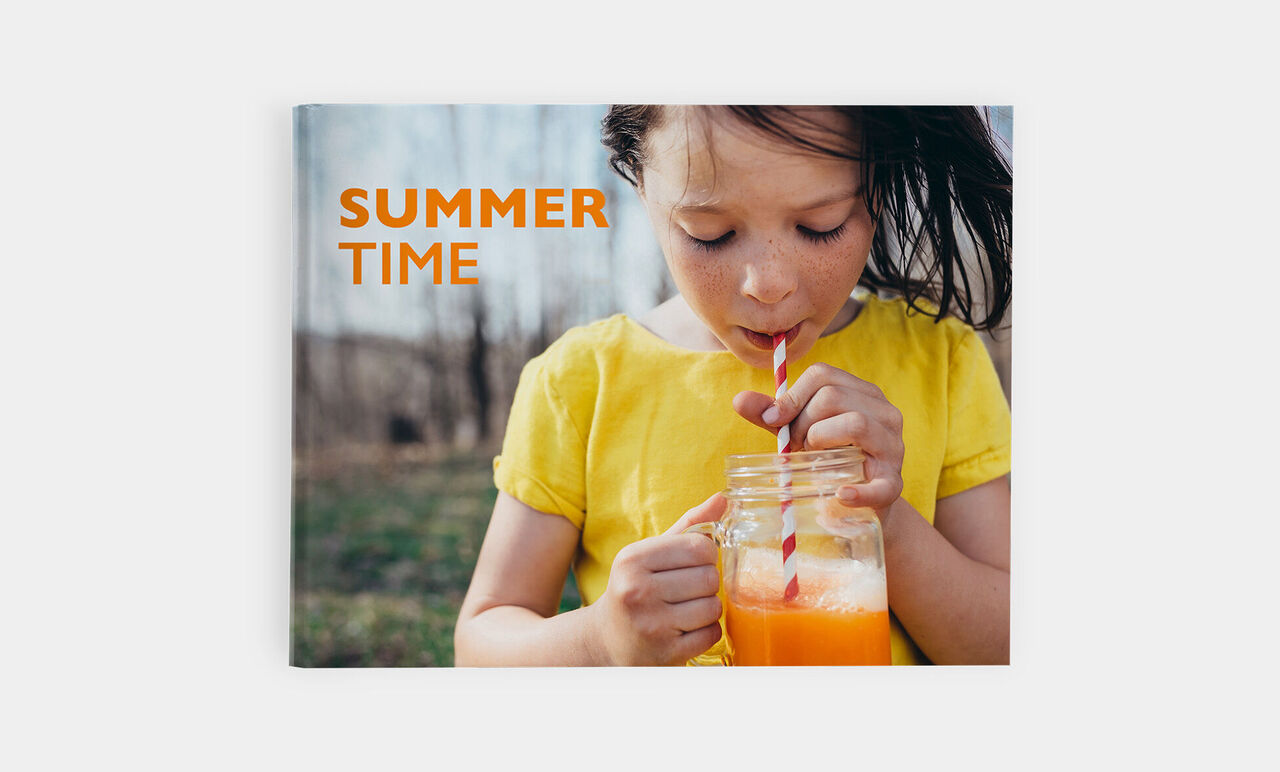 Un bambino in maglietta gialla beve un succo di frutta.