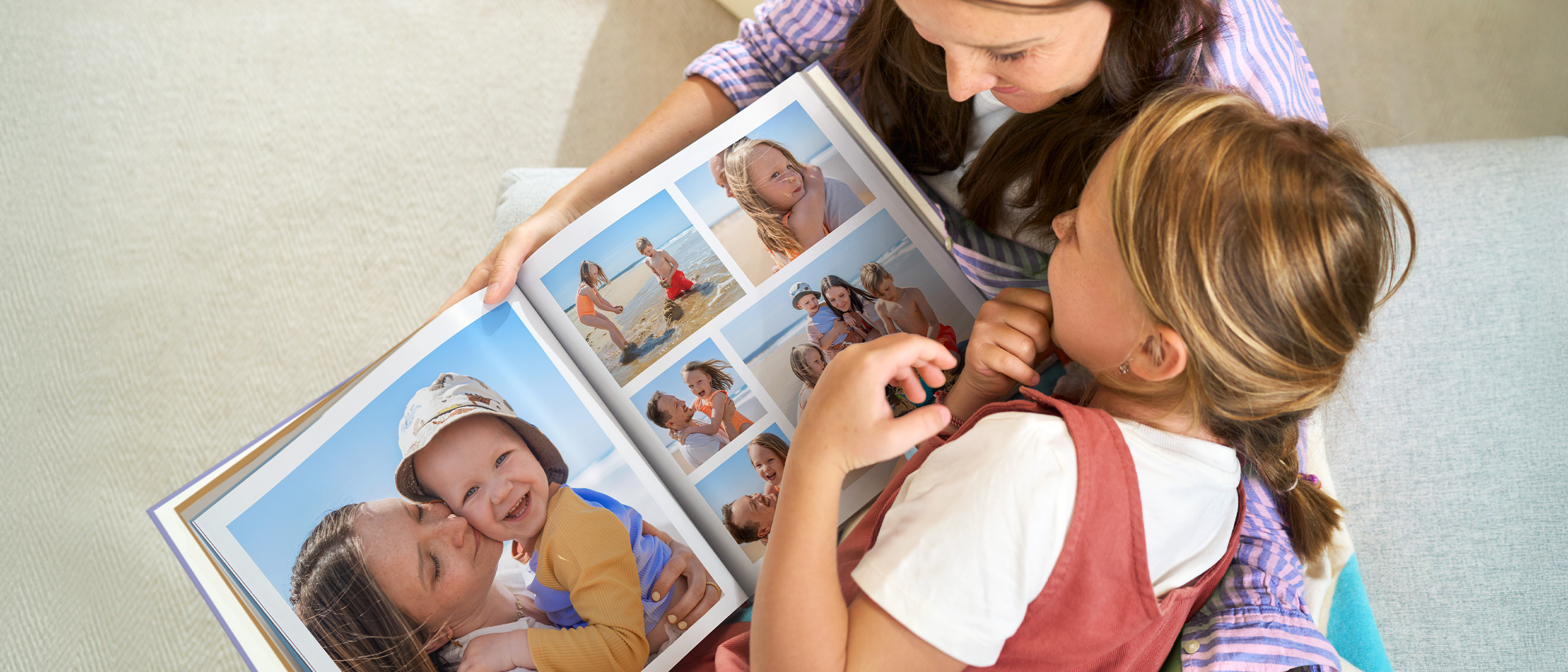 Due bambini guardano insieme un libro fotografico con immagini colorate.