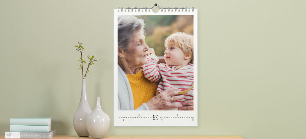 Un bel calendario fotografico mostra una scena affettuosa tra una nonna e suo nipote in un momento tenero.