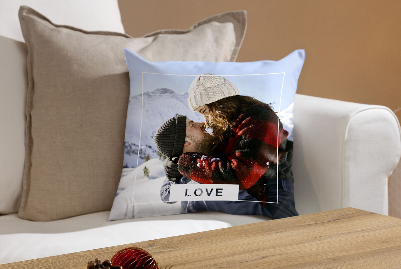 Cuscino con scritta "LOVE" raffigurante una coppia abbracciata nella neve.